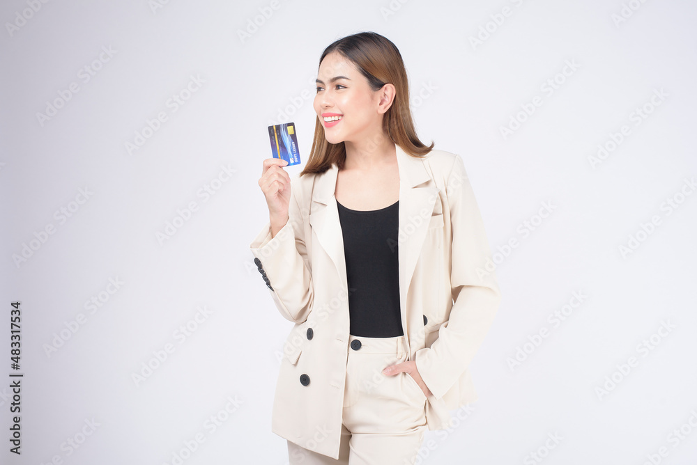 Portrait of Young beautiful woman in suit holding credit card over white background in studio. Portrait of Young beautiful woman in suit holding credit card over white background in studio.