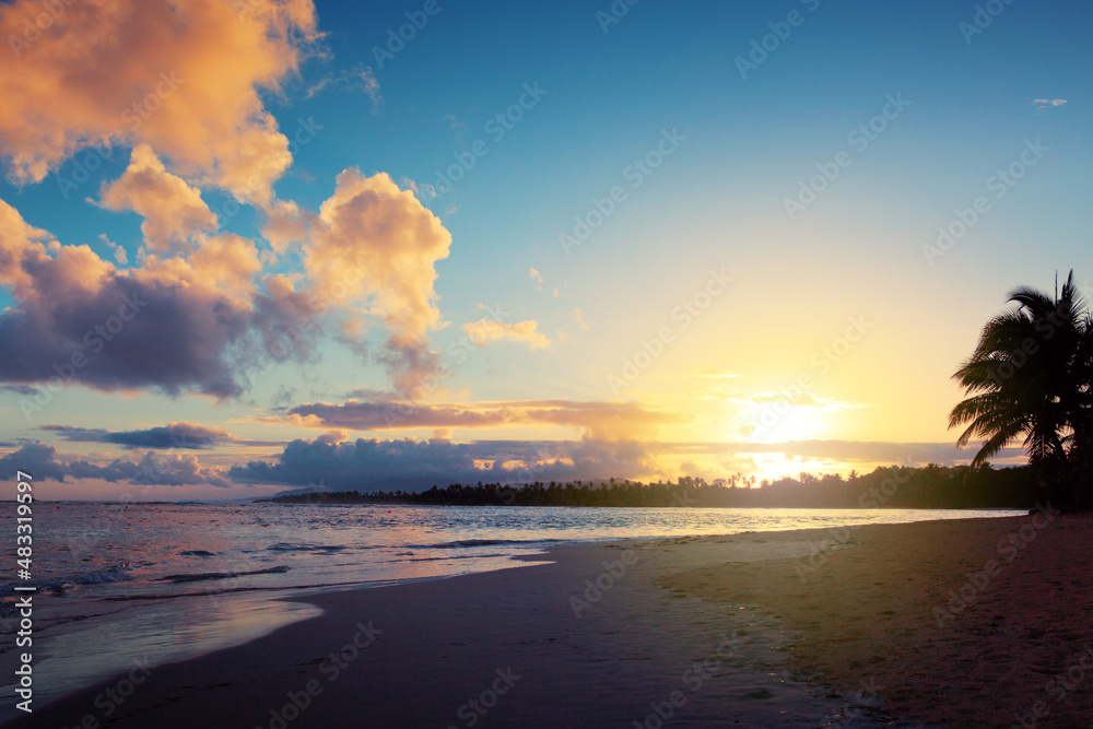 Travel background with Caribbean sunset on tropical beach.