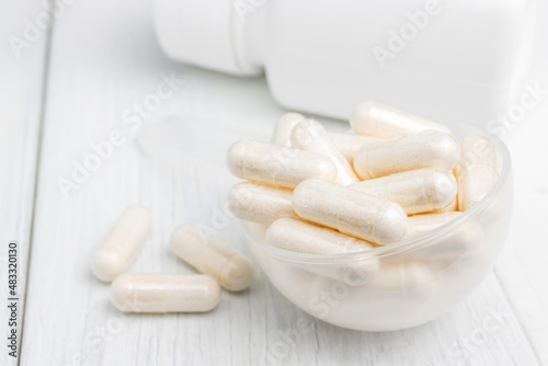 White pills or capsules in a plastic spoon, medication treatment, alternative medicine, close-up view