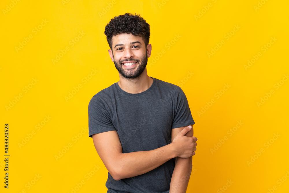 Young Moroccan man isolated on yellow background laughing Young Moroccan man isolated on yellow background laughing