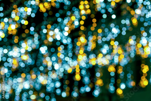 blurred defocused night lights of city on black background, abstract garland shine close up , blue and yellow small round light photo