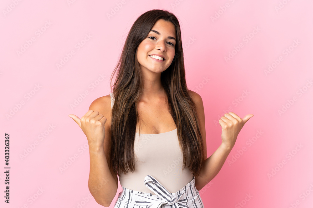 Young brazilian woman isolated on pink background with thumbs up gesture and smiling Young brazilian woman isolated on pink background with thumbs up gesture and smiling