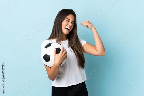 Young football player brazilian girl isolated on blue background celebrating a victory © luismolinero
