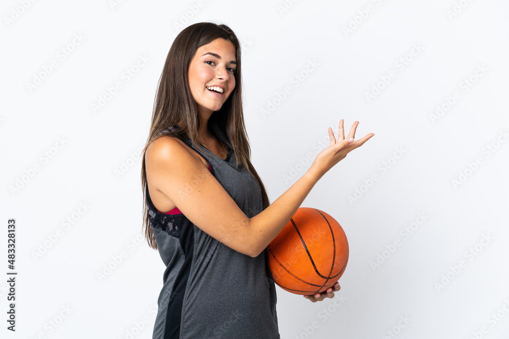 Young brazilian woman playing basketball isolated on white background extending hands to the side for inviting to come Young brazilian woman playing basketball isolated on white background extending hands to the side for inviting to come