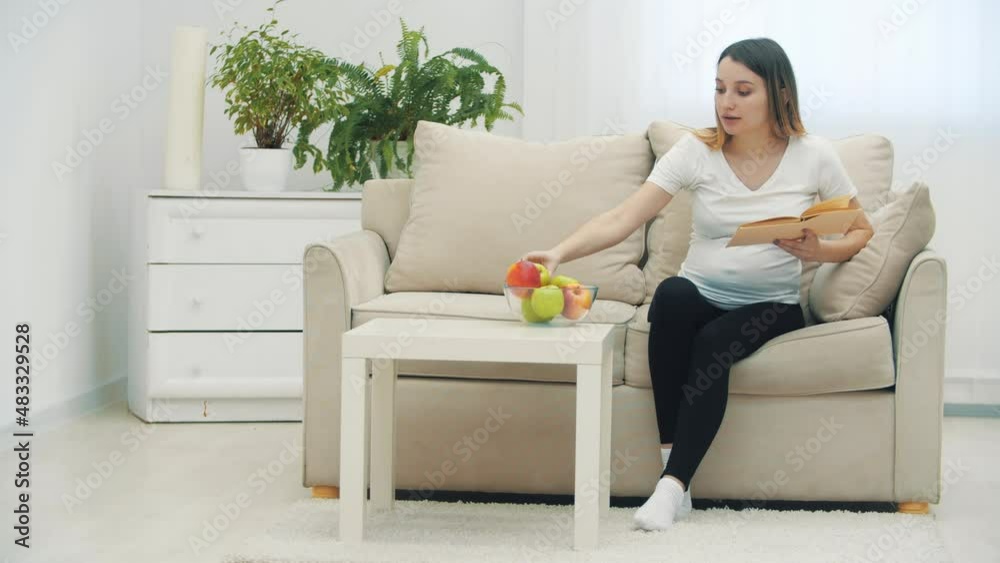 4k video of pregnant woman reading a book and holding an apple. 4k video of pregnant woman reading a book and holding an apple.