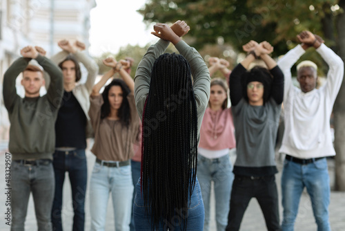 Unrecognizable long-haired black woman leading group of protestors