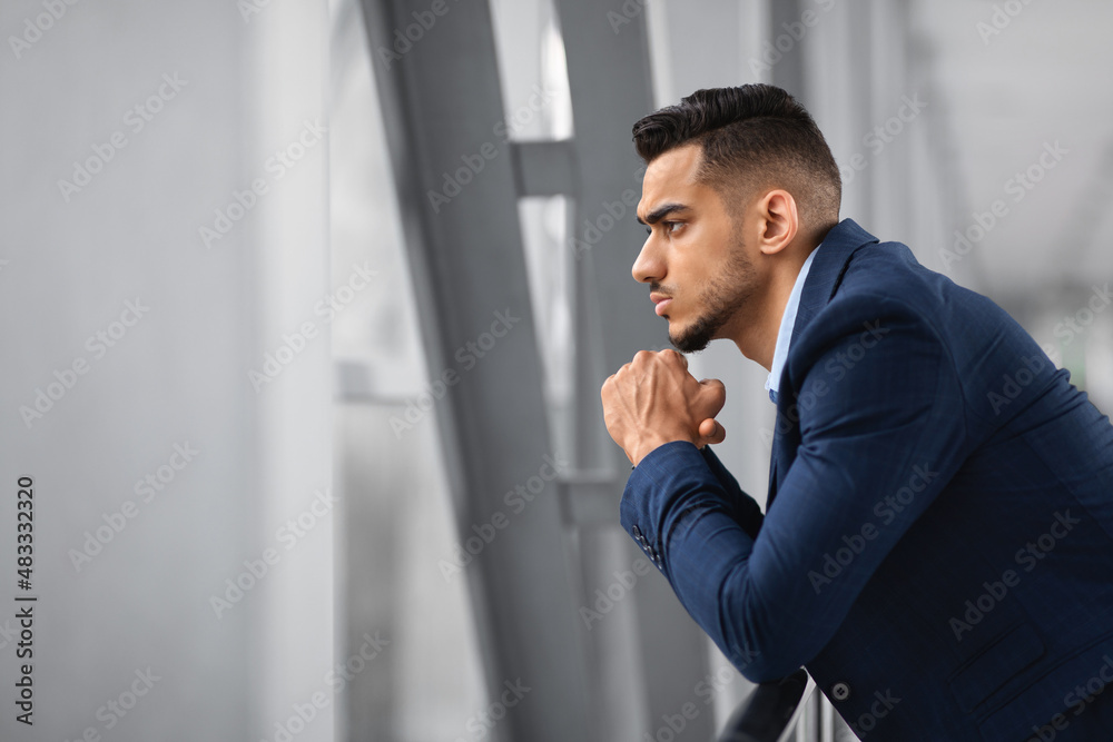Portrait Of Thoughtful Arab Businessman Looking From Window While Waiting At Airport Portrait Of Thoughtful Arab Businessman Looking From Window While Waiting At Airport