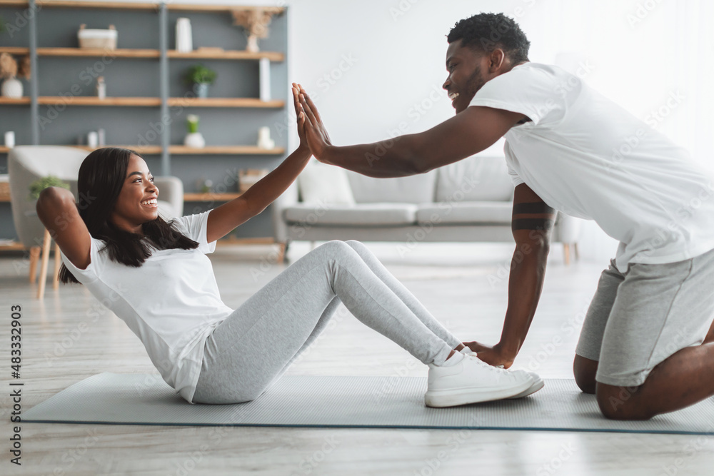 Young black couple doing crunches exercise on abs Young black couple doing crunches exercise on abs