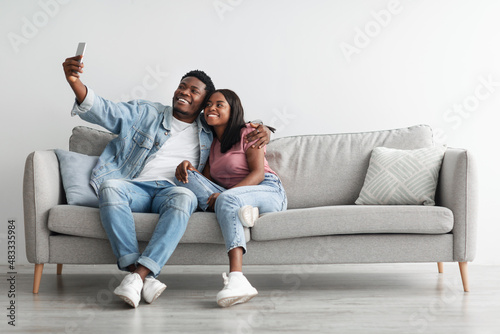 Portrait of african american couple taking selfie together at home