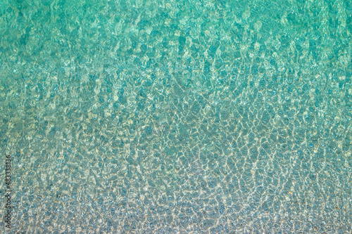 Background, texture of relaxing, calm turquoise, transparent sea water with stones. Summer vacation. Blue ocean lagoon. Drone, copter top view. photo