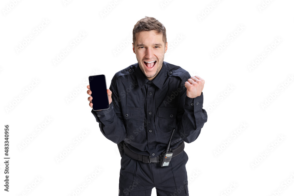 Portrait of young man, policeman officer wearing black uniform using phone isolated on white background. Concept of job, caree, law and order. Portrait of young man, policeman officer wearing black uniform using phone isolated on white background. Concept of job, caree, law and order.