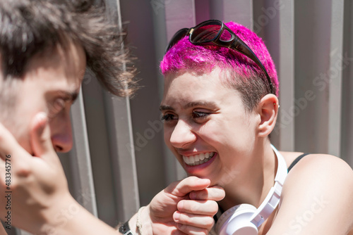 Young couple in love is enjoying of being together. They are looking each other and touching face deicately.