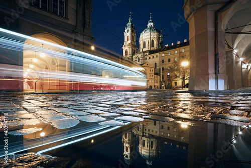 Foto Light trail of tram passing between historic buildings