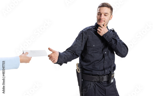 Portrait of young man, policeman wearing black uniform refuses a bribe isolated on white background. Concept of job, caree, law and order. photo