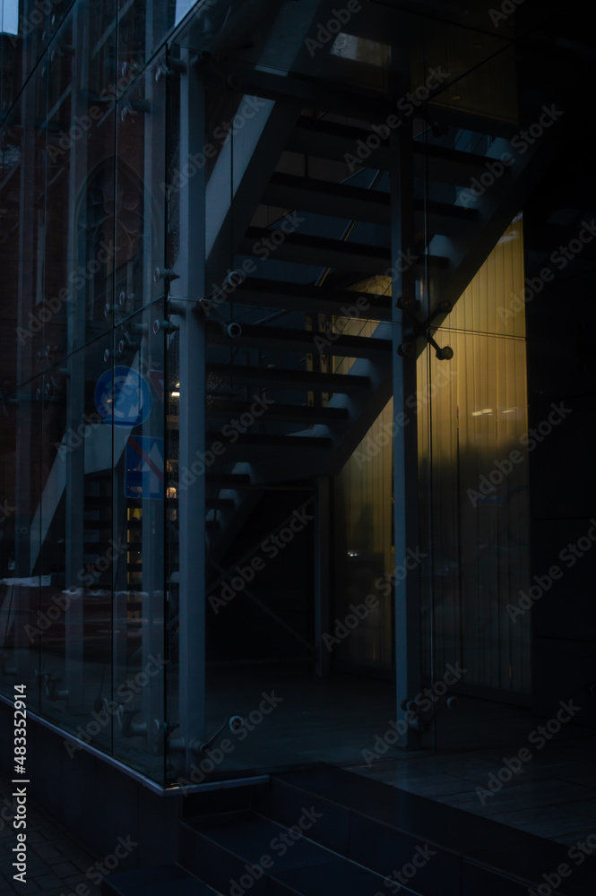 Dark theme city scape with dark entrance, stairs and burning lamp in the darkness