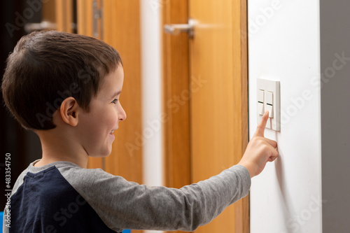 Canvas Print A cropped shot of a little boy switching a light off in his home