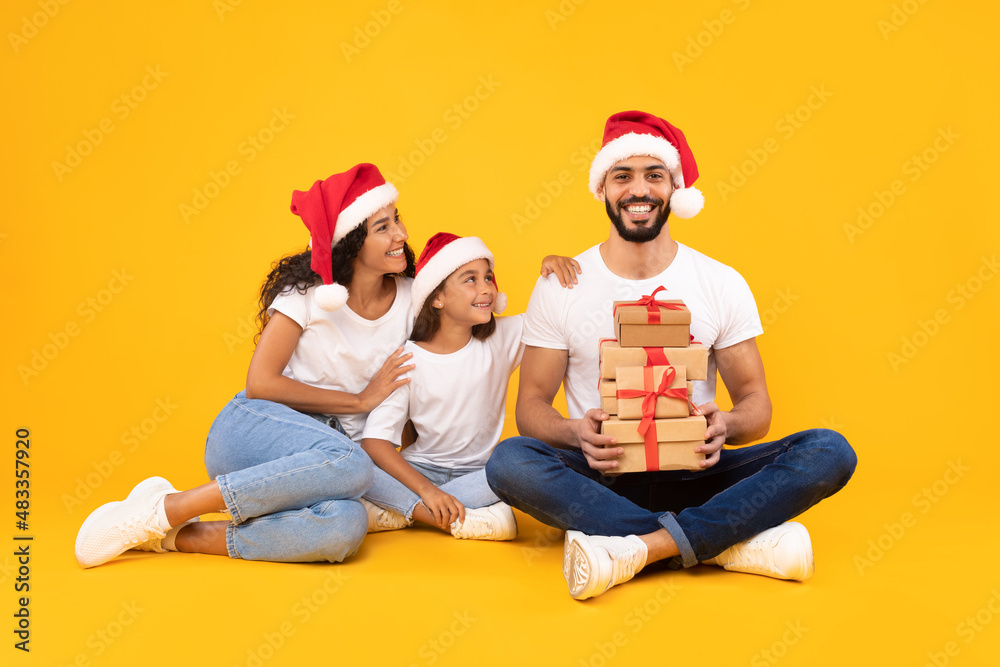 Joyful Arabic Family Posing With Christmas Gifts, Studio Shot Joyful Arabic Family Posing With Christmas Gifts, Studio Shot