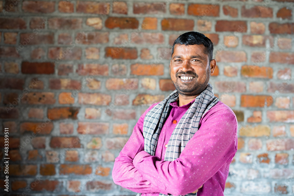 Smiling confident construction worker turns by looking camera at workplace - concept of manual labor and happiness Smiling confident construction worker turns by looking camera at workplace - concept of manual labor and happiness