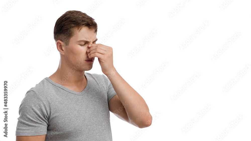 Upset sad millennial european man suffering from runny nose or headache, touching face Upset sad millennial european man suffering from runny nose or headache, touching face
