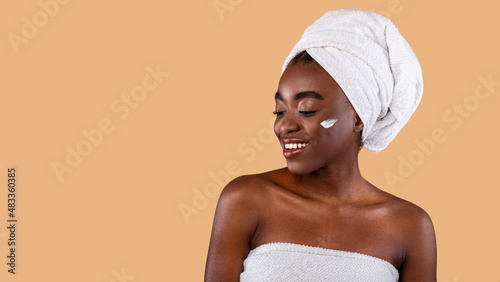 Beautiful young black woman posing with cream on cheek
