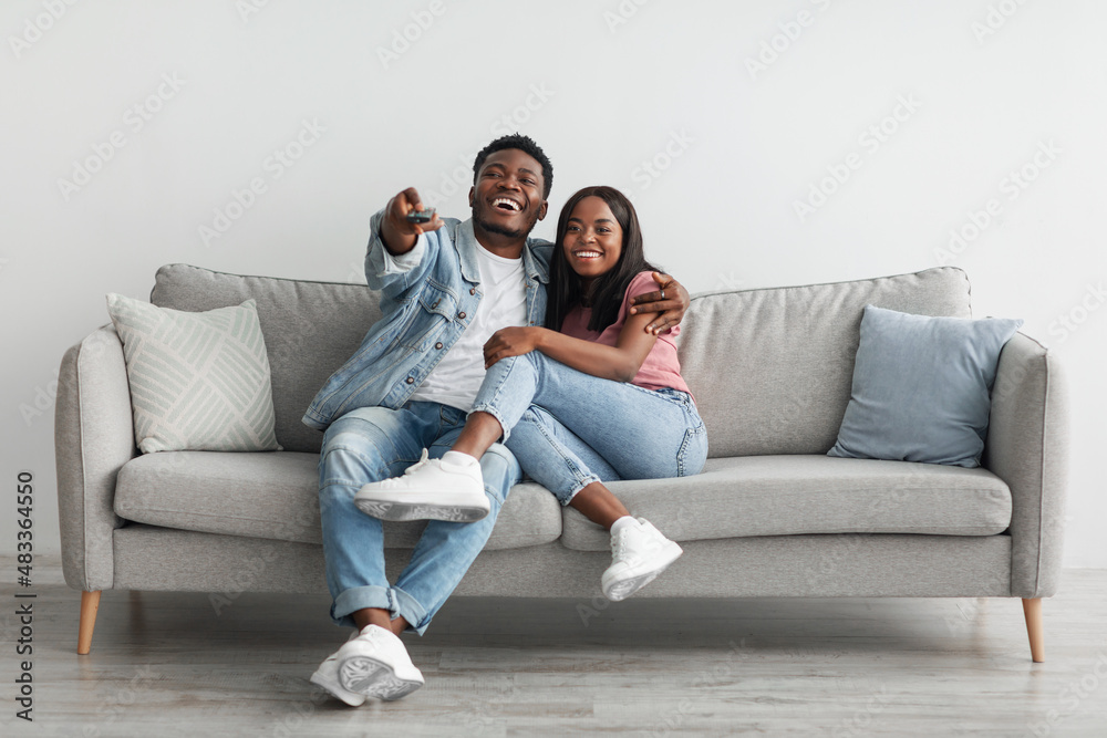 African American couple spending weekend together watching tv