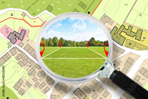 Searching a free Land plot with a vacant land available for building construction - Concept seen through a magnifying glass - note: the map is totally invented and does not represent any real place photo