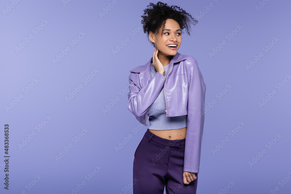 joyful african american woman in violet leather jacket isolated on purple. joyful african american woman in violet leather jacket isolated on purple.
