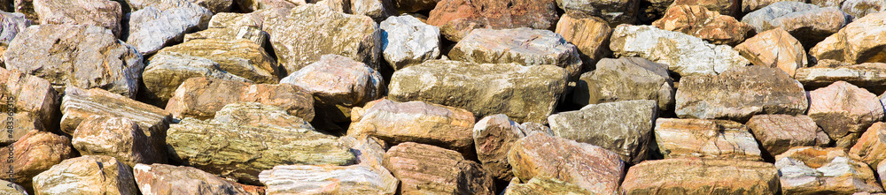 Wall made of rocks and boulders of natural stone - embankment concept