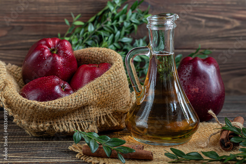 Принти на полотні Apple cider vinegar and red apples on a dark, wooden background