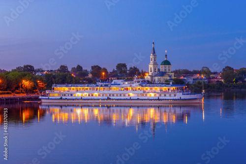 Cruise ship on Volga river against St. Catherine monastery in summer evening. Beautiful night Russian cityscape with cruise liner on water. Travel blog concept. Tver, Russia