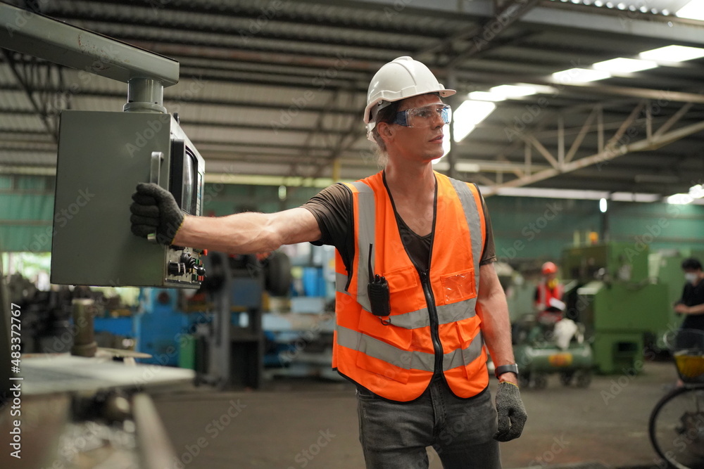 Industrial Engineers in Hard Hats.Work at the Heavy Industry Manufacturing Factory.industrial worker indoors in factory. man working in an industrial factory. Industrial Engineers in Hard Hats.Work at the Heavy Industry Manufacturing Factory.industrial worker indoors in factory. man working in an industrial factory.