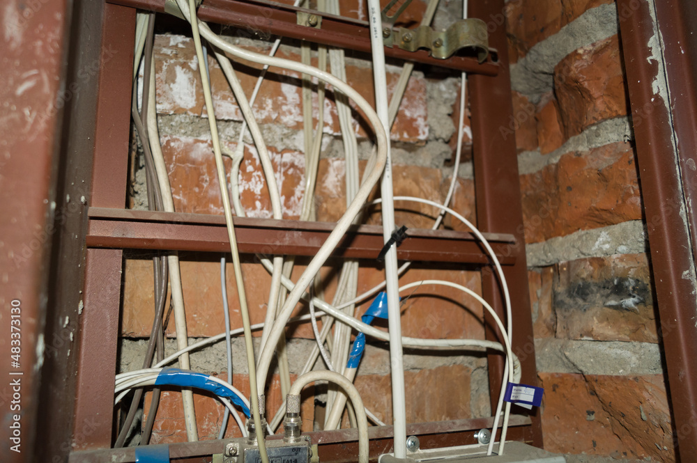 Electric cabinet with Internet and television cables in an apartment building. Niche for wires and cables inside the brick wall. Selective focus