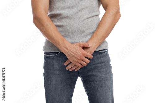 Unrecognizable millennial european guy suffering from health problems and pressing hands to groin © Prostock-studio