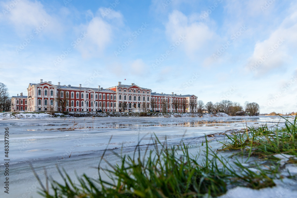 Low angle view to the Latvia University of Life Sciences and Technologies at frozen riverbank in Jelgava, Latvia. Residence for the Dukes of Courland in their capital of Mitau.