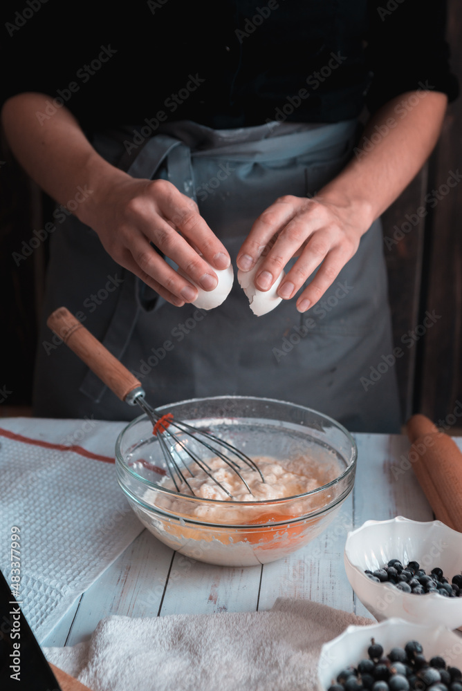 Confectioner breaks the egg and add to the bowl. Confectioner breaks the egg and add to the bowl.