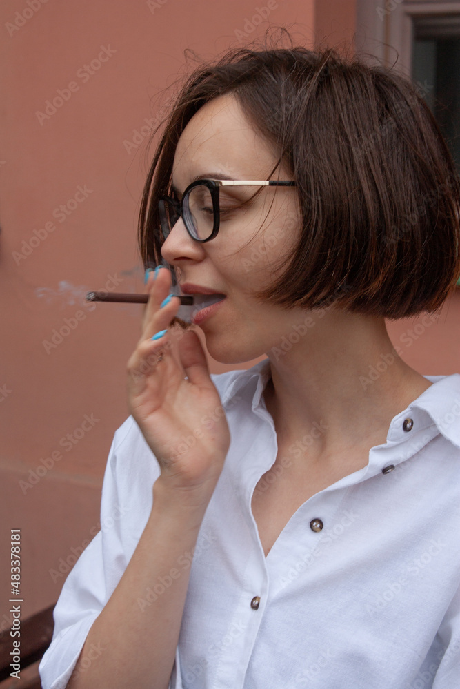 A young woman with short brown hair, wearing a white shirt, with glasses A young woman with short brown hair, wearing a white shirt, with glasses