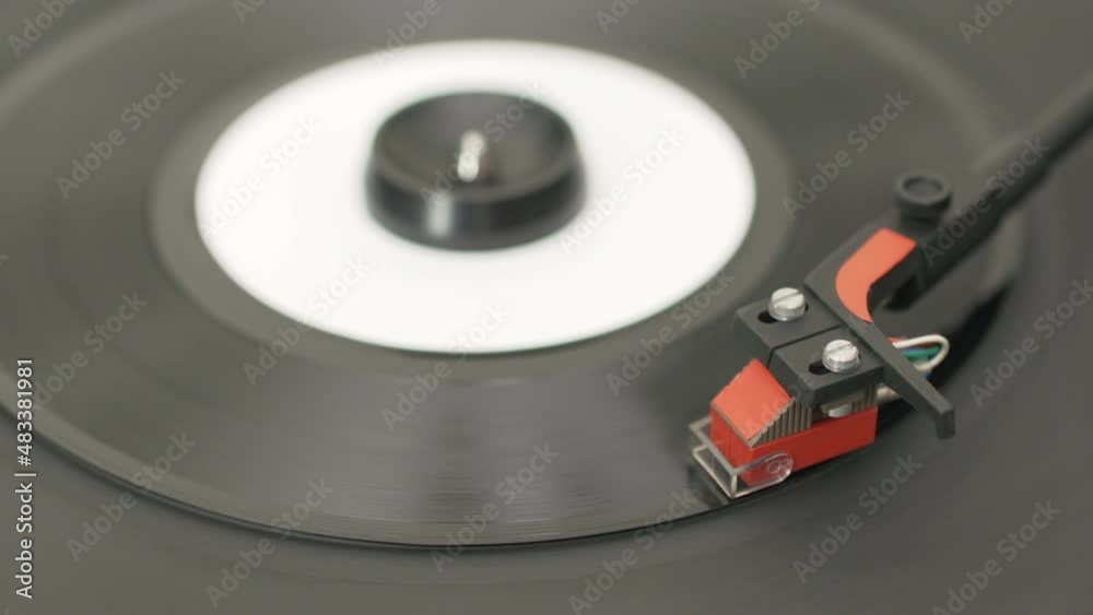 Record player starting to play a 7 inch vinyl record. Realtime video