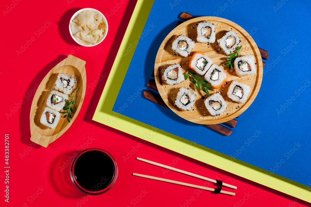 Sushi on a plate on a bright, colored background.