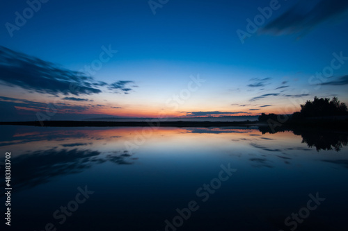 Sunset landscape with sky reflected in water