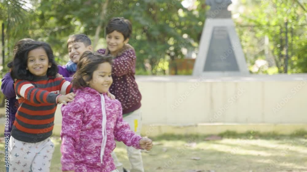 Happy children group playing train game with friends and around the park - concept of children socializing, outdoor physical activities and learning skills. Happy children group playing train game with friends and around the park - concept of children socializing, outdoor physical activities and learning skills.