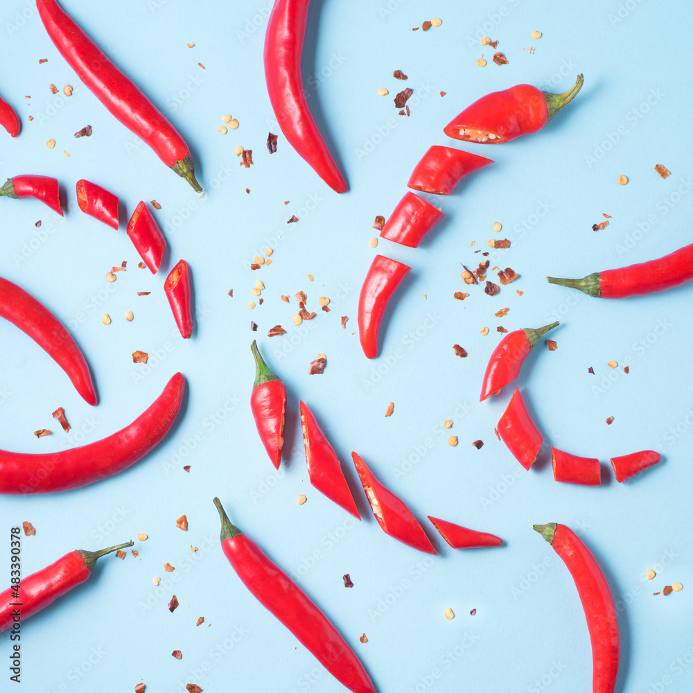 Hot chili pepper background. Hot red peppers on blue, natural spices, , capsaicin, cayenne peppers, top view, square background Hot chili pepper background. Hot red peppers on blue, natural spices, , capsaicin, cayenne peppers, top view, square background