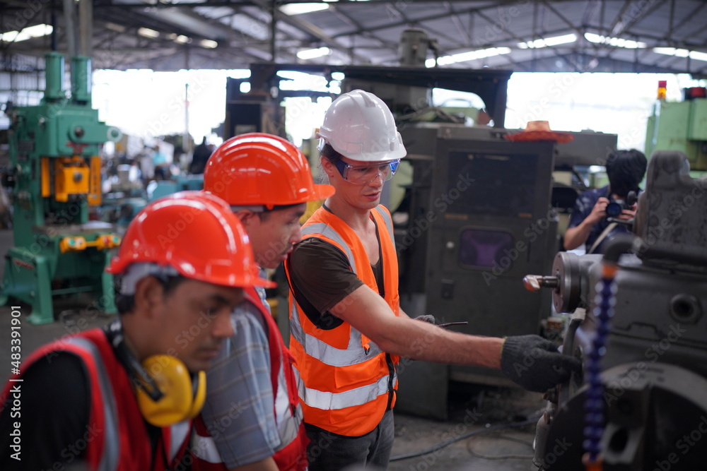 Industrial Engineers in Hard Hats.Work at the Heavy Industry Manufacturing Factory.industrial worker indoors in factory. man working in an industrial factory. Industrial Engineers in Hard Hats.Work at the Heavy Industry Manufacturing Factory.industrial worker indoors in factory. man working in an industrial factory.