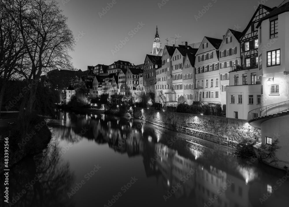 “Neckarfront“ illuminated historic facades of old town of Tuebingen on Neckar River in southern Germany an a winter evening with colorful reflections, Hölderlin Tower and Church