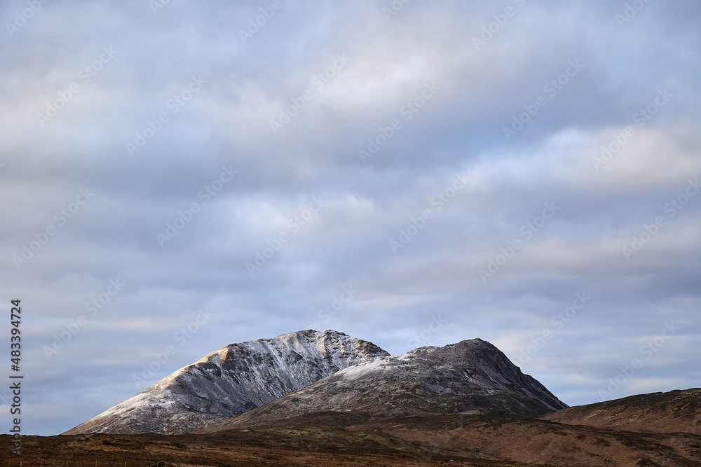 Errigal mountain. County Donegal. snowy peak in winter with cloudy sky and beautiful colors