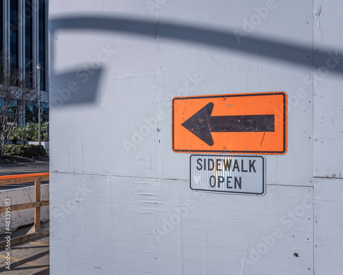 Sidewalk open sign with arrow at construction site. photo