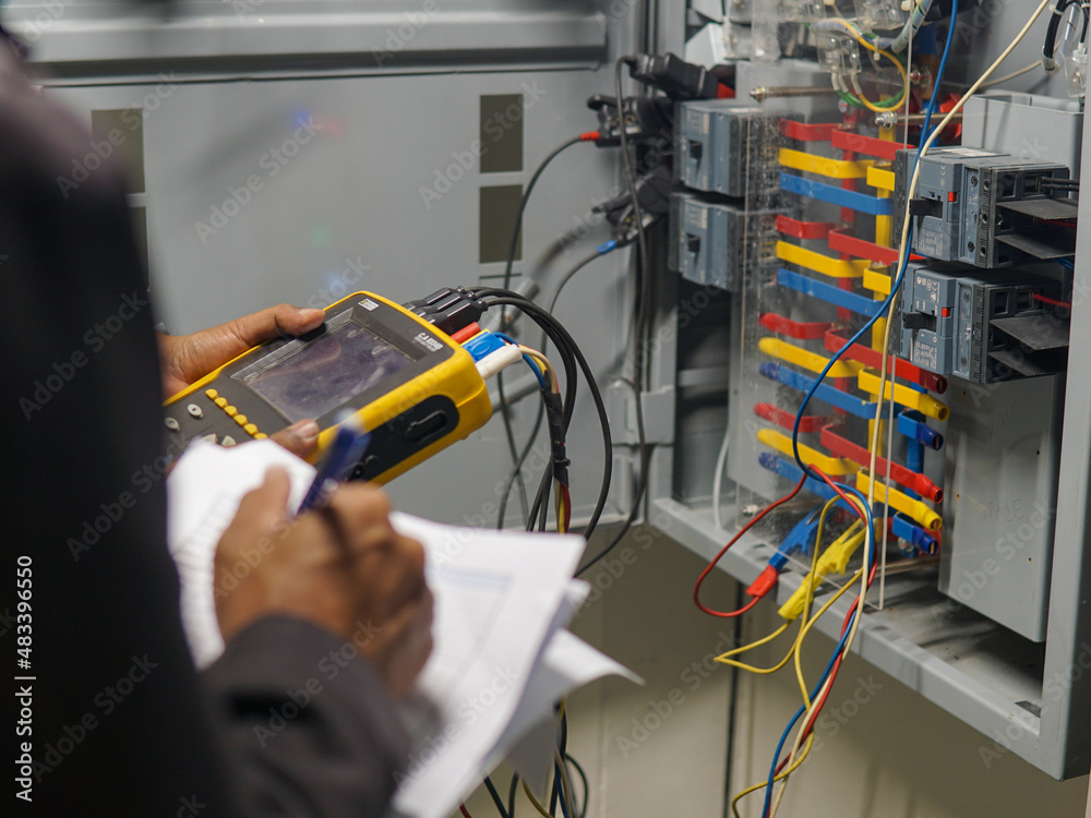 Electrician engineer uses a multimeter to test the electrical