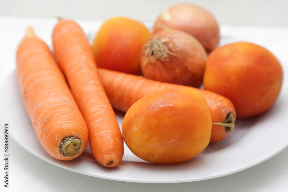 Prato de saladas de cenoura tomate e cebola no prato.
Prato de saladas de cenoura tomate e cebola no prato.