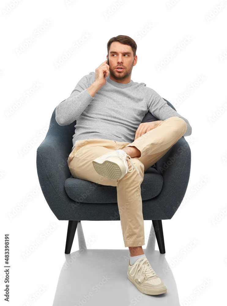 people, communication and technology concept - man sitting in chair and calling on smartphone over white background
