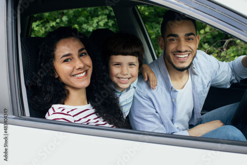 Portrait Of Happy Arab Family Riding Car Together, Smiling Through Window
