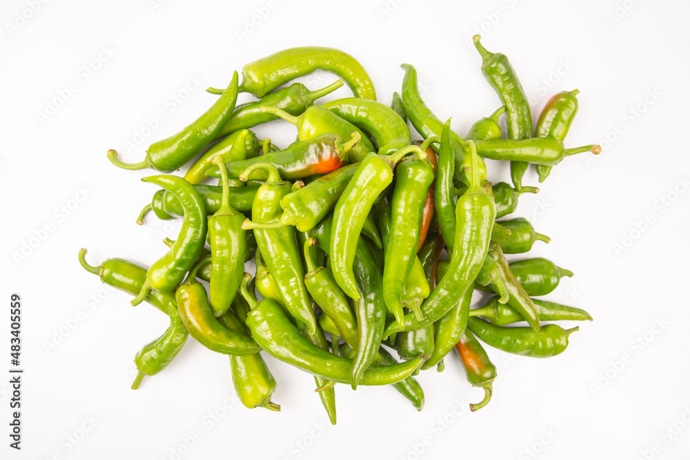 green hot peppers evenly spread on a white background. vitamin vegetables for health green hot peppers evenly spread on a white background. vitamin vegetables for health